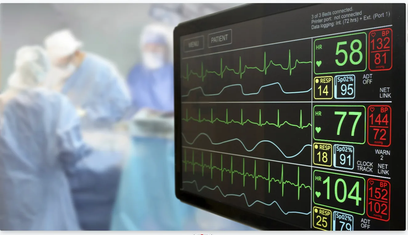 Patient monitor displaying vital signs in a surgical setting